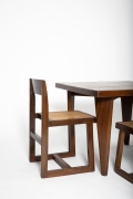 Close up view of Pierre Jeanneret's square table shown with set of 4 Jeanneret chairs