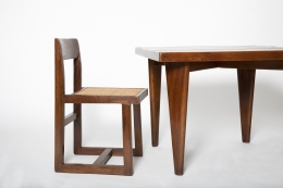 Close up view of Pierre Jeanneret's square table shown with a Jeanneret chair