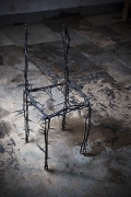Michele Oka Doner's Terrible Chair, full diagonal view from above in a darker warehouse setting